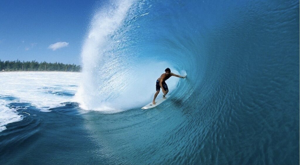 Cavalcare le onde con un surf  dominando la forza del mare.