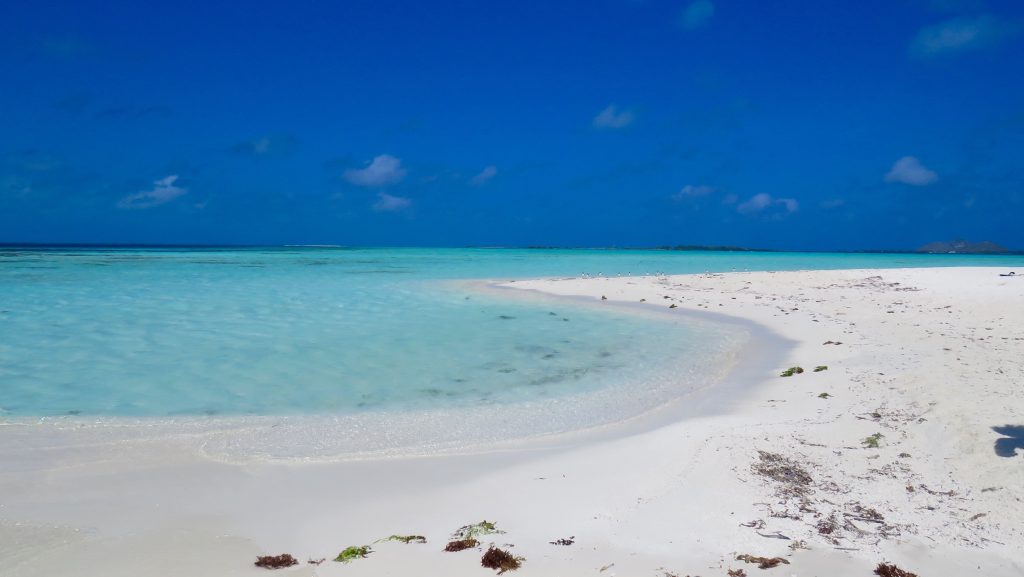 Spiaggia bianca con mare turchese sotto cielo blu