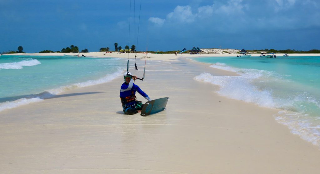 Kitesurfer sulla spiaggia con acqua turchese e palme