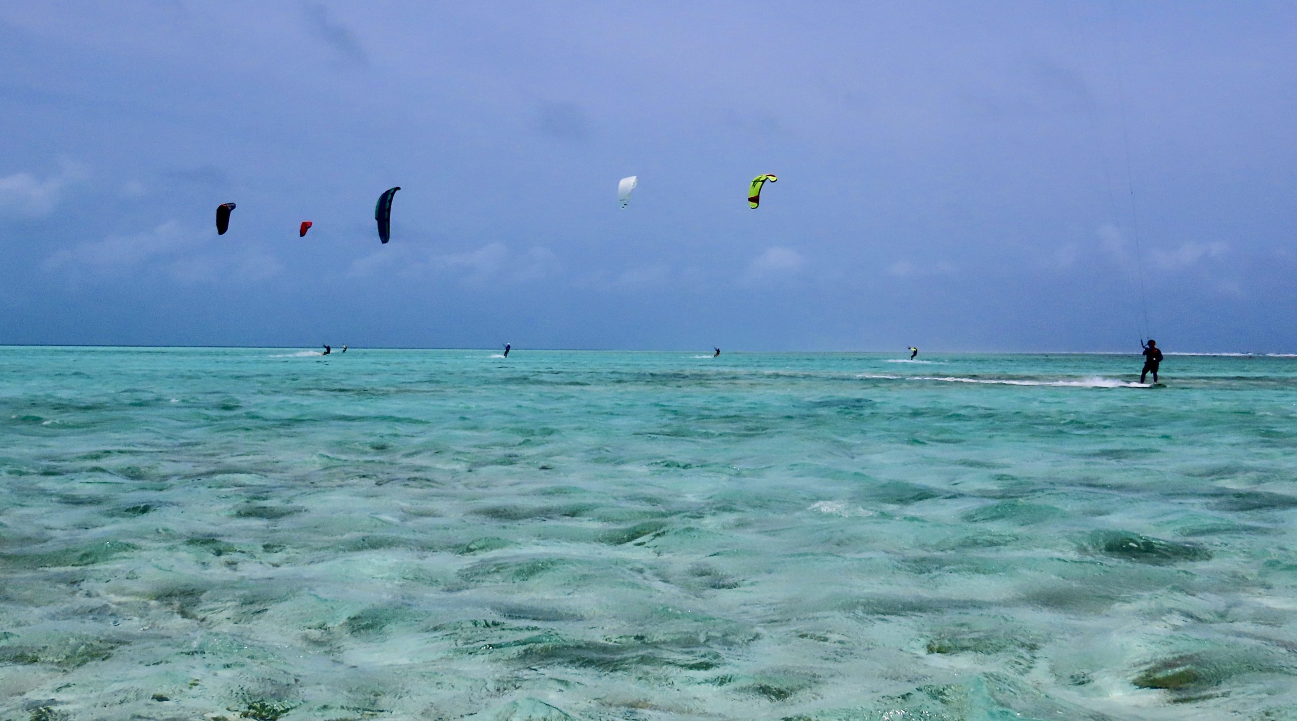 Kitesurfer salta sul mare turchese sotto cielo azzurro